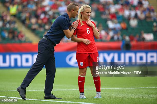 Mark Sampson coach of England talks with Laura Bassett during the FIFA Women's World Cup 2015 third place play-off match between Germany and England...