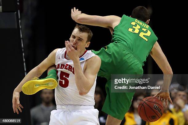 Sam Dekker of the Wisconsin Badgers gets hit in the face by Ben Carter of the Oregon Ducks in the first half during the third round of the 2014 NCAA...