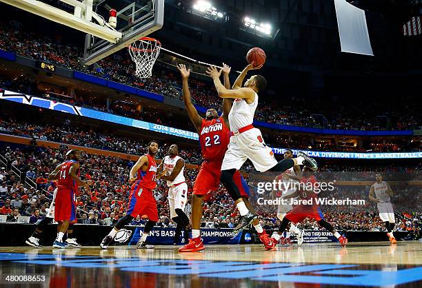 Tyler Ennis of the Syracuse Orange takes a shot as Kendall Pollard of the Dayton Flyers defends during the third round of the 2014 NCAA Men's...