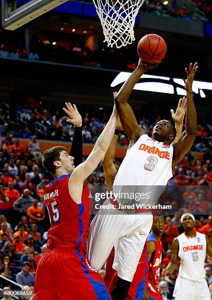 Nolan Hart of the Syracuse Orange goes to the basket as Matt Kavanaugh of the Dayton Flyers defends during the third round of the 2014 NCAA Men's...