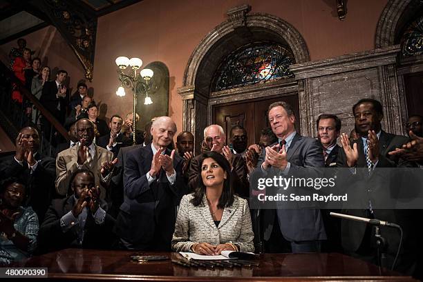 South Carolina Gov. Nikki Haley receives applause after signing a bill to remove the Confederate battle flag from the state house grounds July 9,...