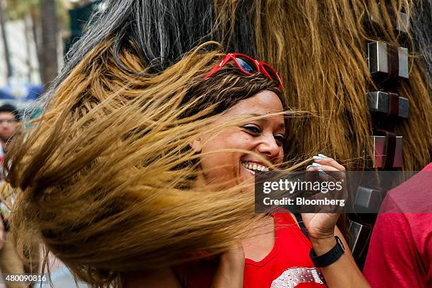 Woman reacts while standing for a photograph with "Star Wars" character Chewbacca during the Comic-Con International convention in San Diego,...