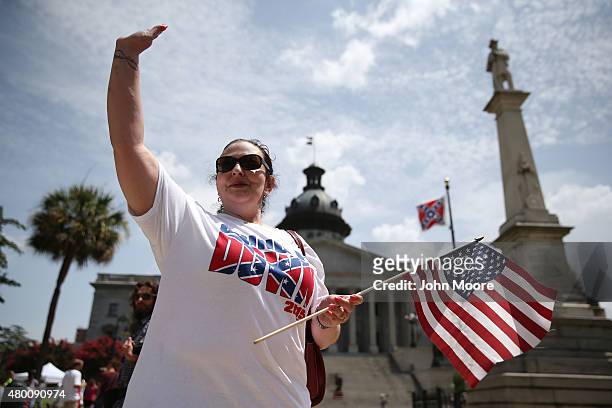 Elisabeth Clements from Charlotte, N.C. Waves to fellow anti-Confederate flag supporters before a ceremony where Governor Nikki Haley was to sign a...