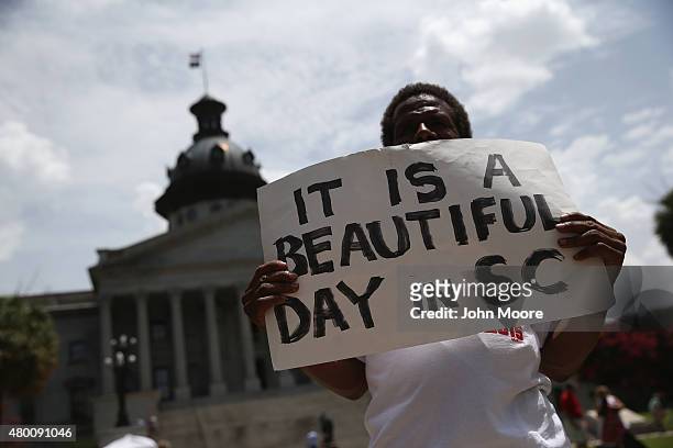 Confederate flag protester holds a sign before a ceremony where Governor Nikki Haley was to sign a bill removing the Confederate flag from outside...