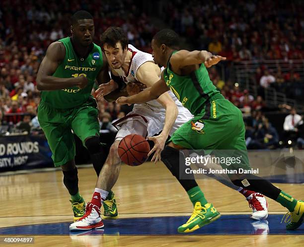 Frank Kaminsky of the Wisconsin Badgers drives to the basket against Johnathan Loyd and Mike Moser of the Oregon Ducks during the third round of the...