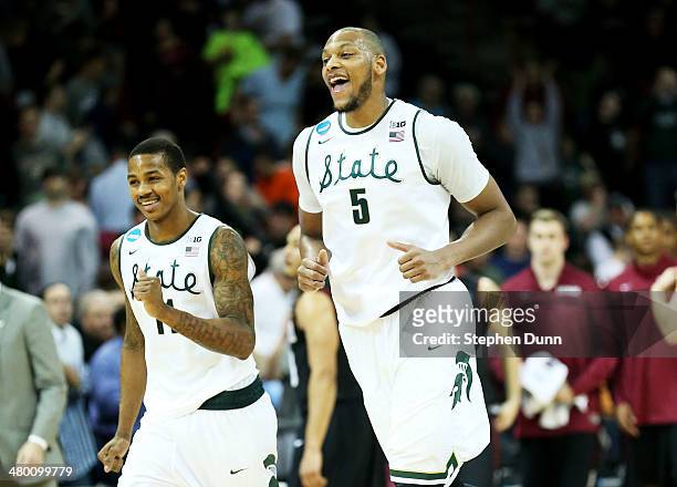 Adreian Payne and Keith Appling of the Michigan State Spartans celebrate their 80 to 73 win over the Harvard Crimson during the Third Round of the...