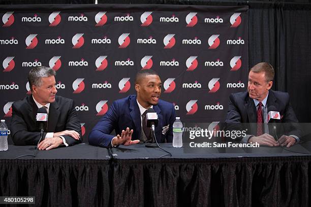 General Manager Neil Olshey and Head Coach Terry Stotts look on as Damian Lillard of the Portland Trail Blazers speaks with the media after signing a...