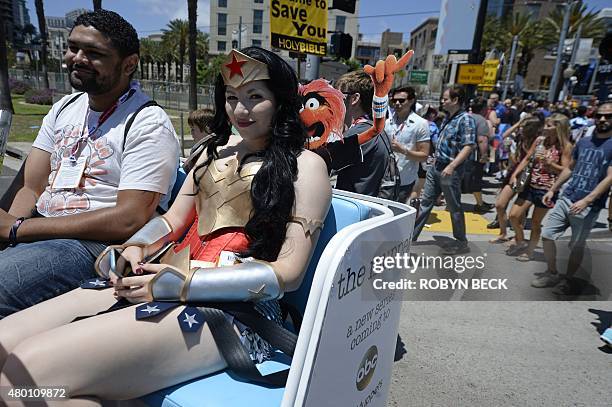 An attendee dressed as Wonder Woman rides in a pedicab on the first day of Comic Con International in San Diego, California, July 9, 2015. AFP PHOTO...
