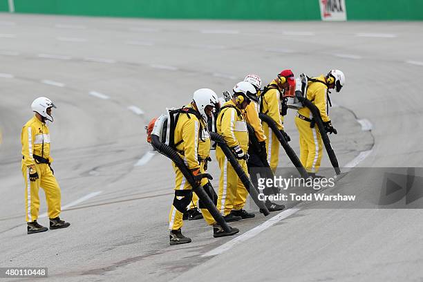 Track workers dry the track before the start of the Camping World Truck Series UNOH 225 at Kentucky Speedway on July 9, 2015 in Sparta, Kentucky.