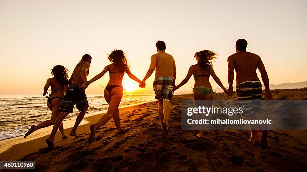 group of friends running at the beach - running design elements stock pictures, royalty-free photos & images
