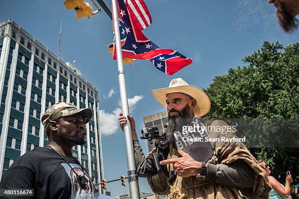 Three men have a peaceful but passionate conversation on the grounds of the South Carolina state house July 9, 2015 in Columbia, South Carolina....