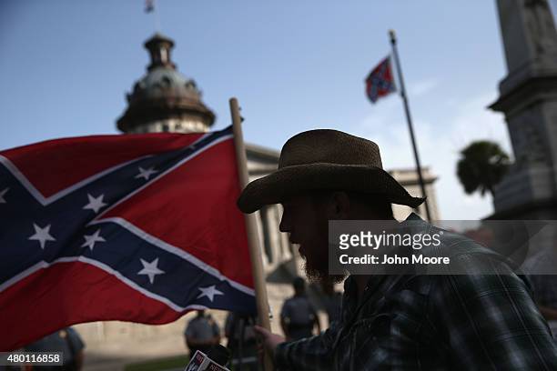 Confederate flag supporter stands outside the South Carolina statehouse as the Confederate flag flies on July 9, 2015 in Columbia, South Carolina....