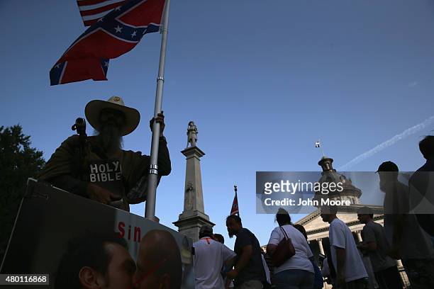Protesters stand outside the South Carolina statehouse as the Confederate flag flies on July 9, 2015 in Columbia, South Carolina. South Carolina...