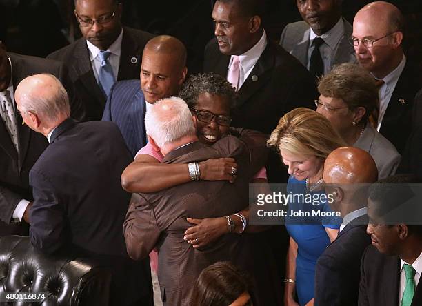 South Carolina Democratic State House Representative Gilda Cobb-Hunter embraces others after Governor Nikki Haley signed a bill to remove the...