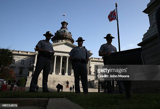 Highway patrolmen stand guard as the Confederate flag flies in front of the South Carolina statehouse for the last full day on July 9, 2015 in...