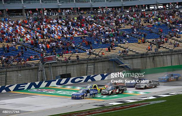 Tyler Reddick, driver of the BBR Music Group Toyota, and Matt Crafton, driver of the Ideal Door/Menards Toyota, lead the field to green during the...