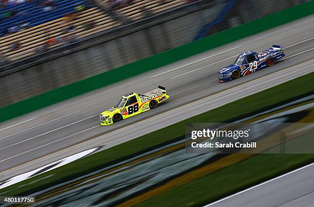 Matt Crafton, driver of the Ideal Door/Menards Toyota, and Ryan Blaney, driver of the Cooper Standard Careers for Vets Ford, race during the NASCAR...