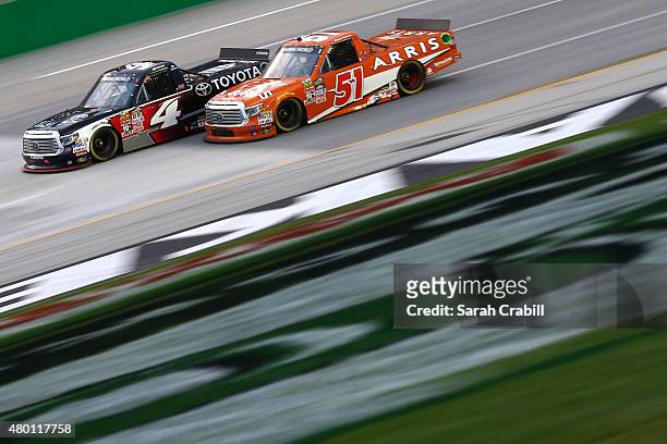 Erik Jones, driver of Special Olympics World Games Toyota, and Daniel Suarez, driver of the ARRIS Toyota, race during the NASCAR Camping World Truck...