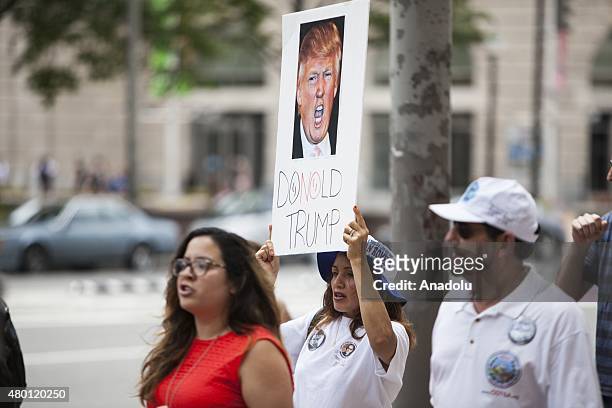 Woman holds a sign while marching to Trump Hotel during a protest against Donald Trump, candidate for the Republican Presidential ticket, after he...