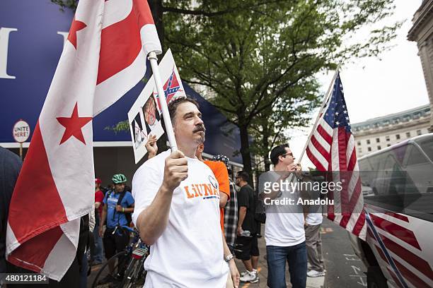 Two men with a District of Columbia flag and an American flag gather in front of the under construction Trump Hotel to protest Donald Trump,...