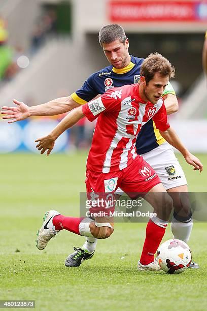 Mate Dugandzic of the Heart runs is tackled by Nick Montgomery of the Mariners during the round 24 A-League match between Melbourne Heart and the...