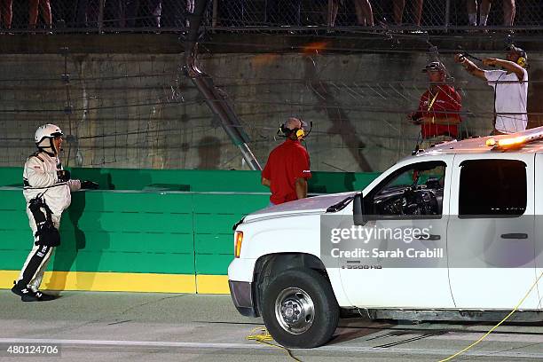 Track officials repair a damaged catch fence during the NASCAR Camping World Truck Series UNOH 225 at Kentucky Speedway on July 9, 2015 in Sparta,...