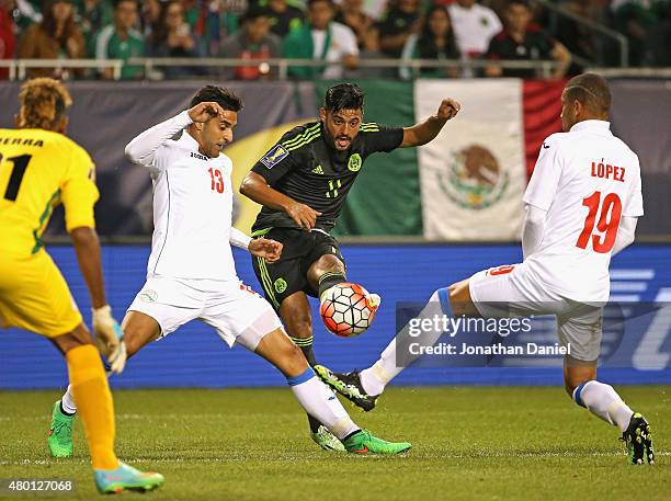 Carlos Vela of Mexico fires a shot between Jorge Corrales and Yasmani Lopez of Cuba during a match in the 2015 CONCACAF Gold Cup at Soldier Field on...