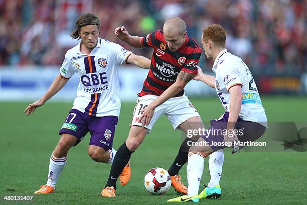 Aaron Mooy of the Wanderers competes for the ball with Chris Harold and Jack Clisby of the Glory during the round 24 A-League match between the...