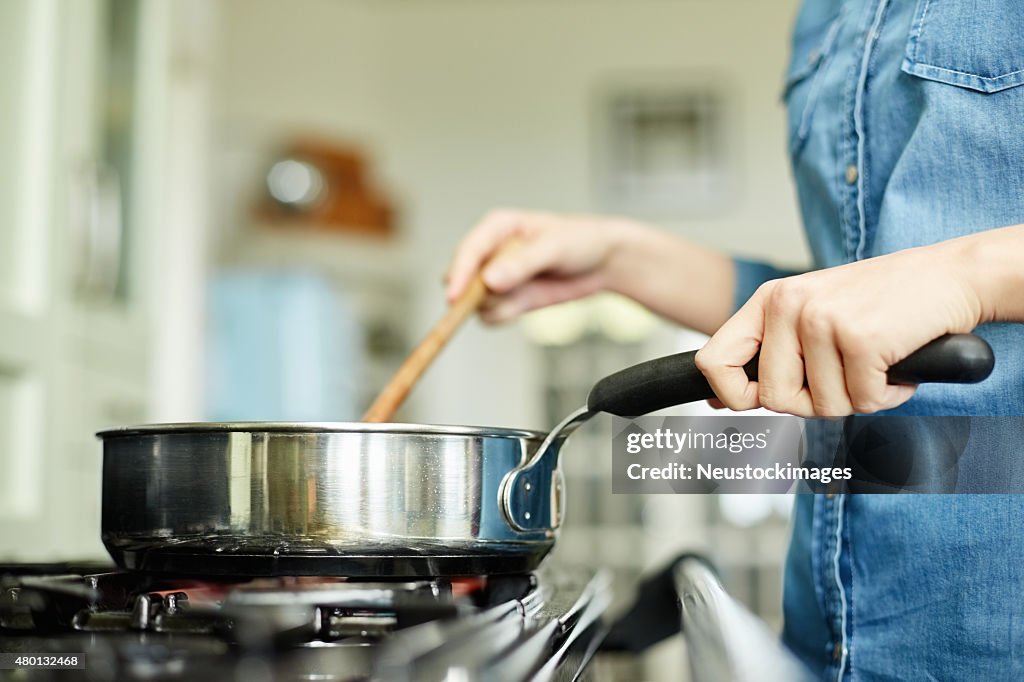 Bauchgegend Bild der Frau Kochen Küche in der Pfanne