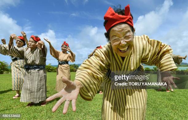 In this picture taken on June 22 an elderly women troupe of singers and dancers from Kohama Island in Okinawa wearing traditional local costumes...