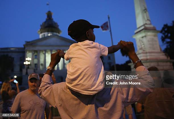 Family visits as the Confederate flag flies in front of the South Carolina statehouse on its last evening on July 9, 2015 in Columbia, South...