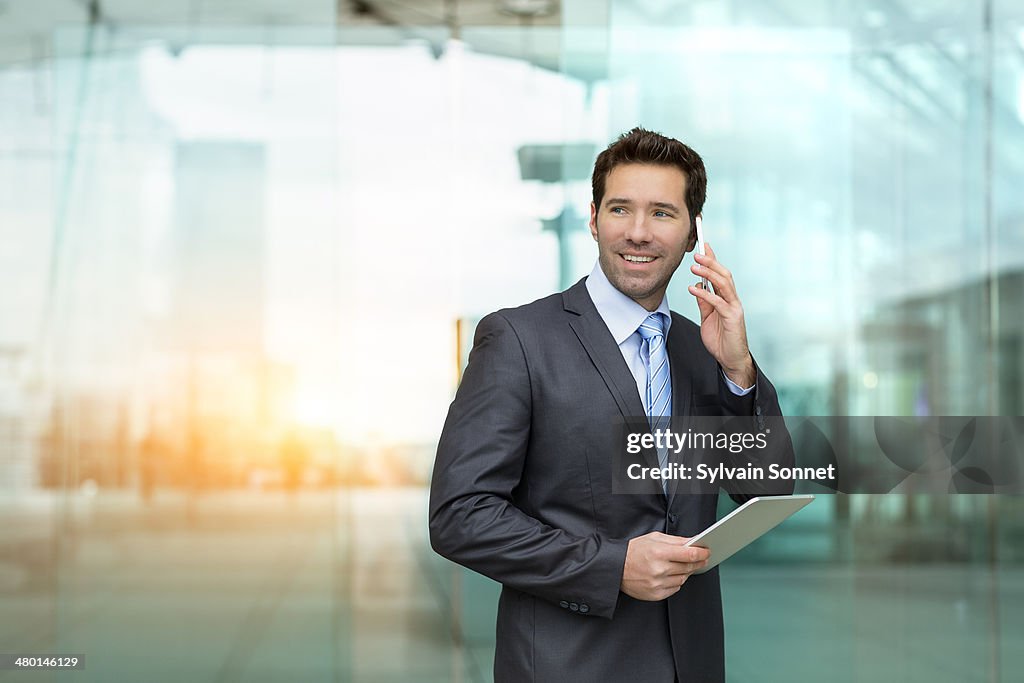 Business man using phone and Digital Tablet