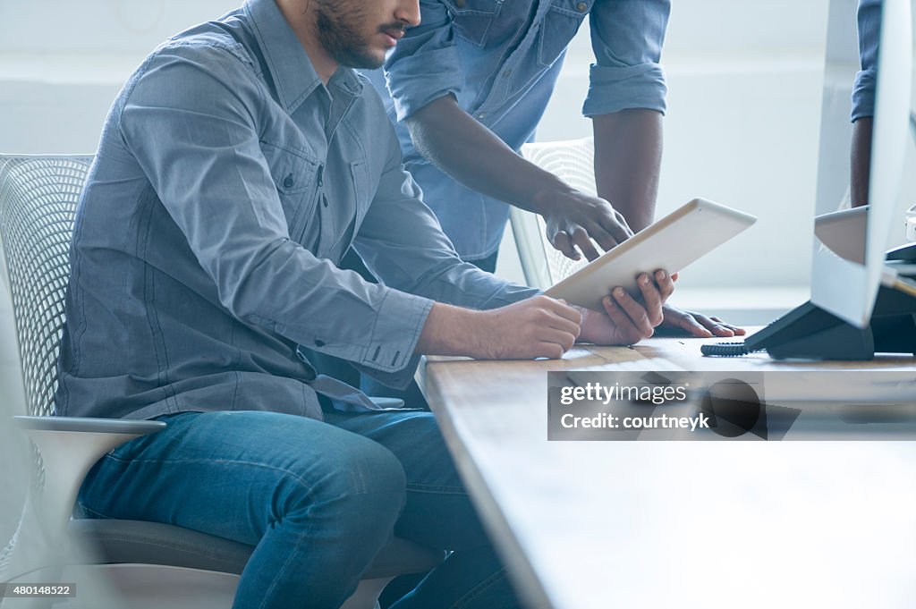 Two business people working on a digital tablet.
