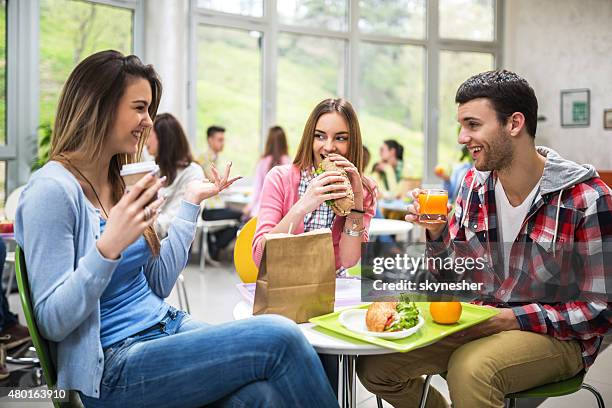 group of students communicating during lunch in cafeteria. - cafeteria stock pictures, royalty-free photos & images