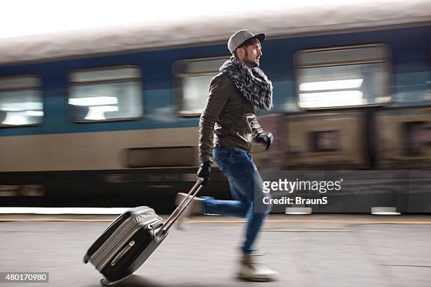 young man in blurred motion trying to catch the train. - catching train stock pictures, royalty-free photos & images