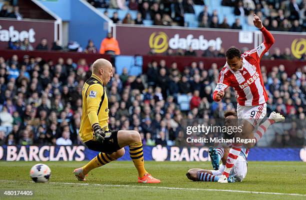 Peter Odemwingie of Stoke shoots past goalkeeper Brad Guzan of Aston Villa to score a goal to level the scores at 1-1 during the Barclays Premier...