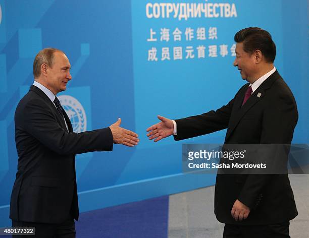Russian President Vladimir Putin greets Chinese President Xi Jinping during the Shanghai Cooperation Organisation Summit on July 10 2015 in Ufa,...