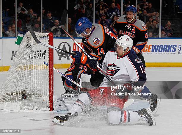 Thomas Hickey of the New York Islanders holds up Cam Atkinson of the Columbus Blue Jackets as he takes the first period shot at the Nassau Veterans...