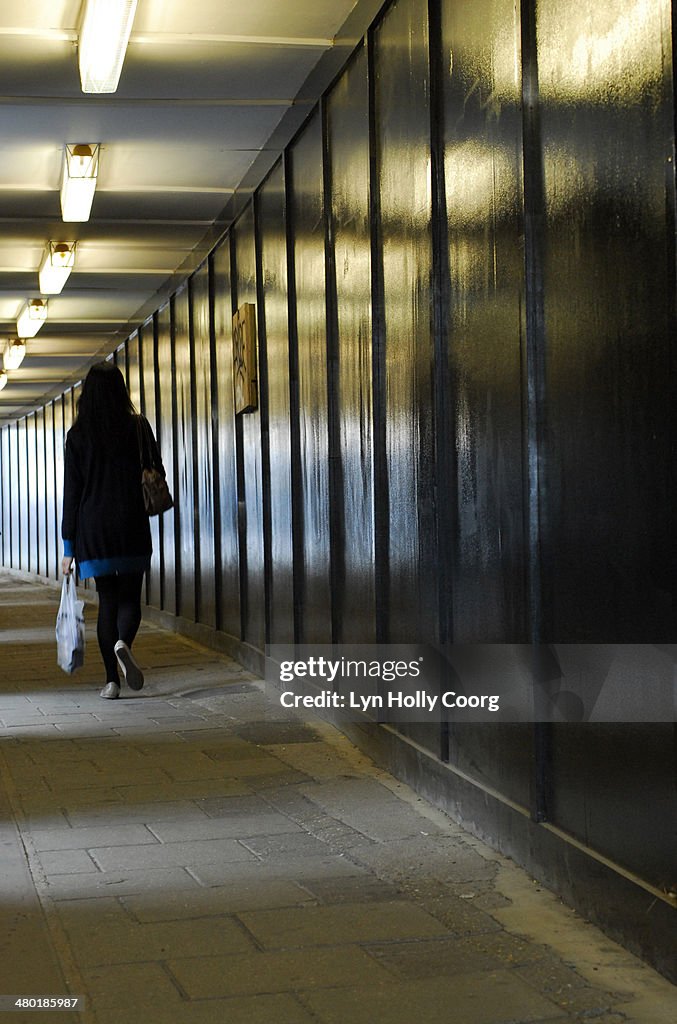 Woman carrying shopping walking through underpass