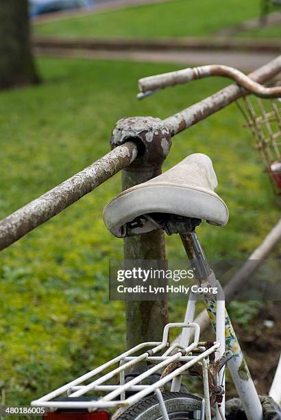 old white bike leaning on rusty railings - lyn holly coorg stockfoto's en -beelden