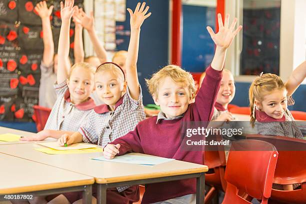 happy school children answering a question in the classroom - beckoning stock pictures, royalty-free photos & images