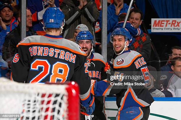 Cal Clutterbuck of the New York Islanders celebrates his first period goal with teammates Johan Sundstrom and Frans Nielsen during the game against...