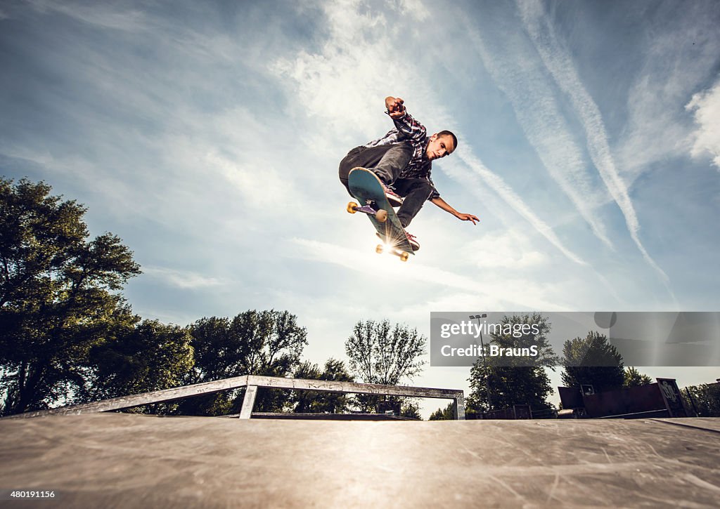Below view of a street skateboarder in Ollie position.