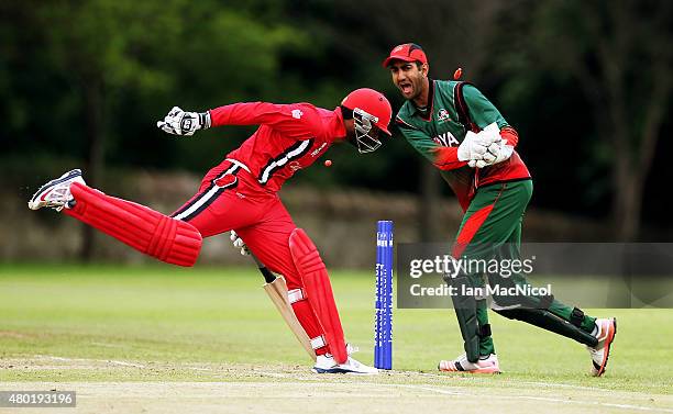 Navneet Dhaliwal of Canada gets in despite the efforts of Rakep Patel of Kenya during the ICC World Twenty20 India Qualifier between Canada and Kenya...