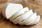 Single ball of mozzarella cheese sliced and isolated on rustice