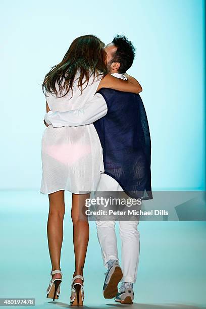 Designer Emre Erdemoglu and a model walk the runway after his show during the Mercedes-Benz Fashion Week Berlin Spring/Summer 2016 at Brandenburg...