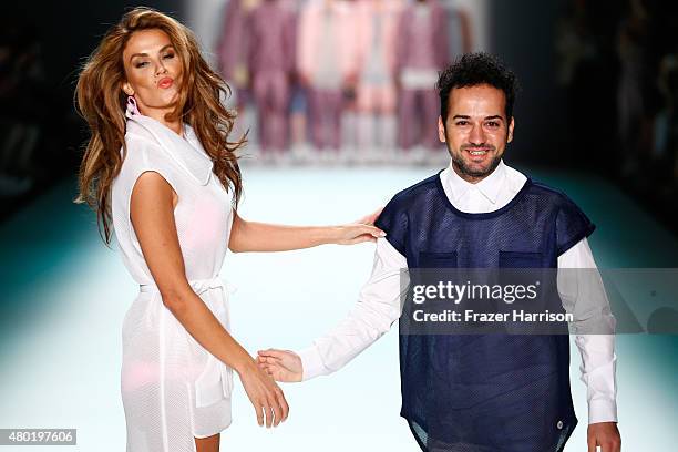 Designer Emre Erdemoglu and a model walk the runway after his show during the Mercedes-Benz Fashion Week Berlin Spring/Summer 2016 at Brandenburg...