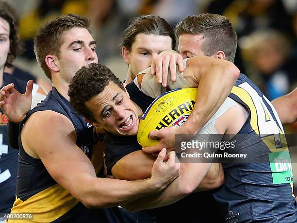Ed Curnow of the Blues is tackled by Anthony Miles and Kane Lambert of the Tigers during the round 15 AFL match between the Richmond Tigers and the...