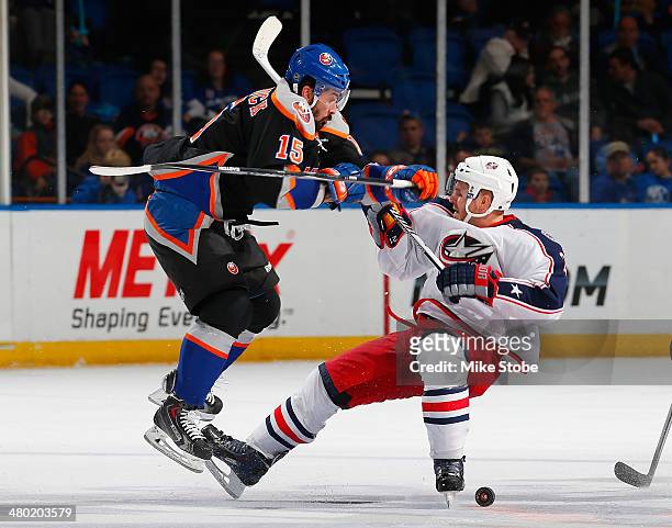 James Wisniewski of the Columbus Blue Jackets is checked by Cal Clutterbuck of the New York Islanders at Nassau Veterans Memorial Coliseum on March...