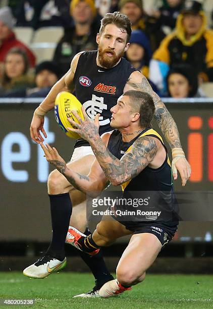 Dustin Martin of the Tigers marks infront of Zach Tuohy of the Blues during the round 15 AFL match between the Richmond Tigers and the Carlton Blues...